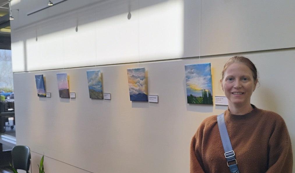 Artist, Cecilia stands next to art collection, VIEWS, on display at the Ronald H Library in Temecula